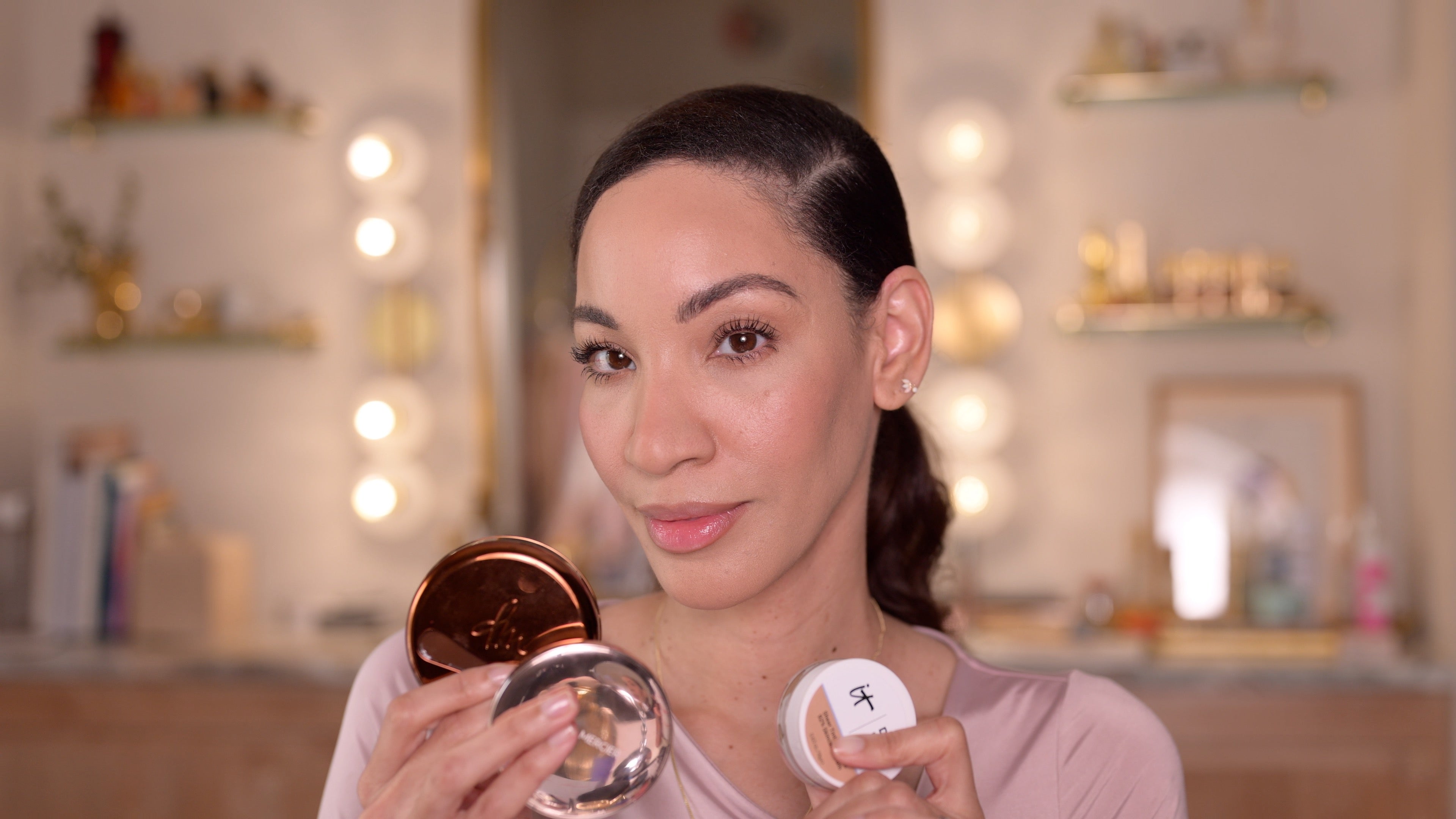 Saj Mack makeup artist holding three different foundation to showcase which foundation suits the skin